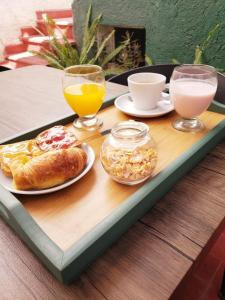 un vassoio con prodotti per la colazione e bevande su un tavolo di Hotel Namaste a Mendoza