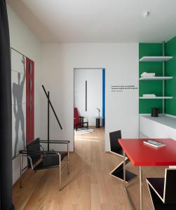sala de estar con mesa roja y sillas en Interno Marche Design Experience Hotel, en Tolentino