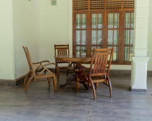 Villa Verde Alawwa في Alawwa: طاولة وكراسي خشبية في الغرفة