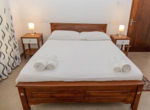 1 dormitorio con 1 cama grande y 2 mesitas de noche en Villa Verde Alawwa en Alawwa