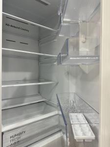 an empty refrigerator with its door open with its shelves at Luxury two-room apartment with beautiful mountain views in Almaty