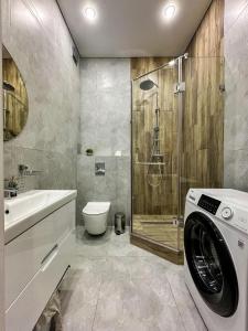 a bathroom with a washing machine and a shower at Luxury two-room apartment with beautiful mountain views in Almaty