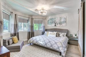 a bedroom with a bed and a couch and windows at Lakefront Coeur dAlene Home with Deck and Shared Dock in Coeur d'Alene
