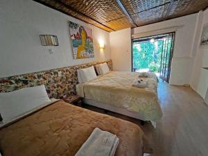 Habitación de hotel con 2 camas y ventana en JoãoeMaria da Ilha, en Praia de Araçatiba