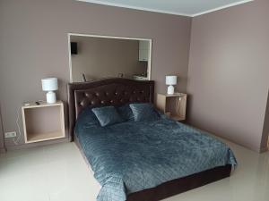 1 dormitorio con cama y espejo grande en Lambertu ielas rezidence, en Mārupe