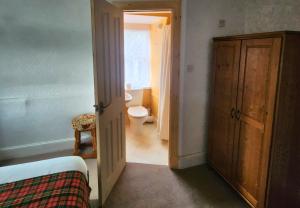 a room with a bathroom with a toilet and a door at The Retreat Hotel in Strathpeffer
