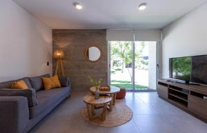 ein Wohnzimmer mit Sofa und Fernseher in der Unterkunft The Acacia Village in Ciudad Lujan de Cuyo