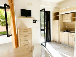 a kitchen with a tv and a sliding glass door at Hotel Park Village in Rossano