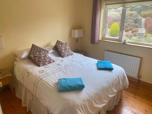 een slaapkamer met een bed met twee blauwe handdoeken erop bij Superior 4 bedroom House Moville in Moville