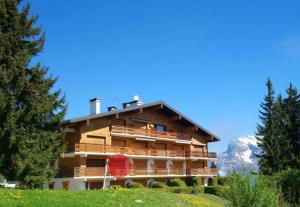 Ein Gebäude auf einem Hügel mit Bergen im Hintergrund in der Unterkunft Studio Bettex 4p- vue Mont-Blanc in Saint-Gervais-les-Bains