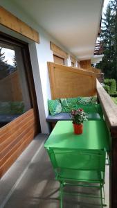 ein grüner Tisch mit einer Topfpflanze auf einem Balkon in der Unterkunft Studio Bettex 4p- vue Mont-Blanc in Saint-Gervais-les-Bains