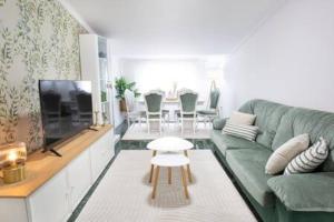 a living room with a green couch and a table at Apartamento con Piscina Ribadumia in Ribadumia