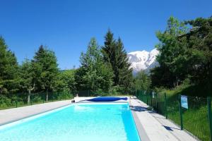 ein Swimmingpool mit einem Berg im Hintergrund in der Unterkunft Studio Bettex 4p- vue Mont-Blanc in Saint-Gervais-les-Bains