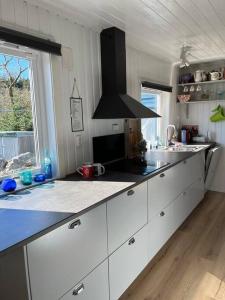 a kitchen with white cabinets and a black counter top at 4 Person Holiday Home Sletta 