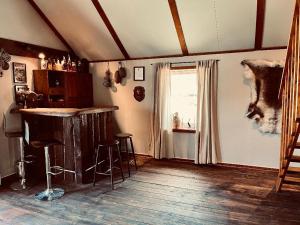 Zimmer mit einer Bar mit Hockern und einem Fenster in der Unterkunft The Fisher's cabin in Stjoerdal