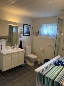 a bathroom with a sink and a toilet and a bed at 4 Person Holiday Home Sletta 