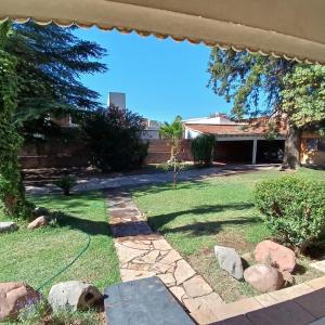 a backyard with a lawn and a house at Mendoza - Casa Cardozo in Guaymallen