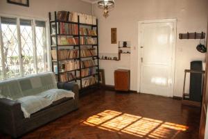 sala de estar con sofá y estantería con libros en Mendoza - Casa Cardozo en Guaymallén