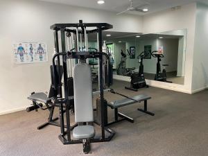 Un gimnasio con varias máquinas de correr y un espejo. en Broadways Best, en Sídney