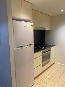 una cocina con refrigerador y estufa en Broadways Best, en Sídney