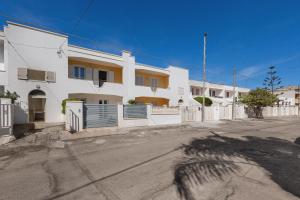 a white house with a fence in front of it at Appartamento Giade by BarbarHouse in Torre dell'Orso