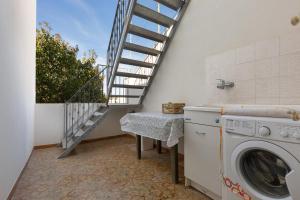 a laundry room with a staircase and a washing machine at Appartamento Giade by BarbarHouse in Torre dell'Orso