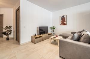 un soggiorno con divano e TV di Modern & Bright Central Home Wi-Fi & A/C a Mellieħa