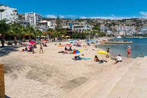 a group of people on a beach with umbrellas at DEA Room 2 in Sarandë