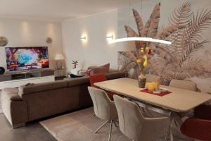 a living room with a couch and a table with flowers at Superior Haus 120 qm mit Garten in Düsseldorf