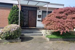 una puerta delantera de una casa con un árbol en Superior Haus 120 qm mit Garten en Düsseldorf