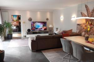 een woonkamer met een bank en een tv bij Superior Haus 120 qm mit Garten in Düsseldorf
