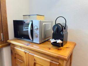 un forno a microonde e una radio su un tavolo di legno di La Casetta Vintage - Central Bormio with Garage a Bormio