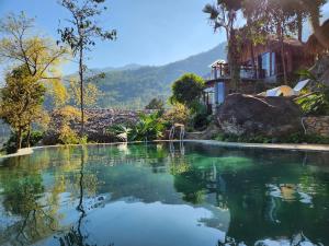 una piscina de agua frente a una casa en Pu Luong Paradise en Hương Bá Thước