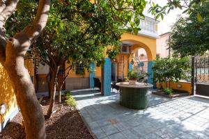 a courtyard with trees and a yellow building at La Casa di Bianca in Follonica