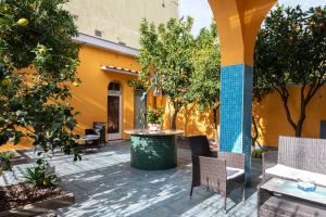 eine Außenterrasse mit Tischen, Stühlen und Orangenbäumen in der Unterkunft La Casa di Bianca in Follonica