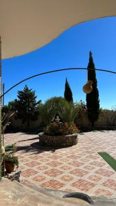 vista su un patio con giardino fiorito sotto ombrellone di الجبل الاخضر سيق ( بيت الصوير ) a Sayq