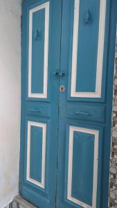a blue door with two windows on a building at Maison de ville sousse in Sousse