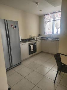 a kitchen with a refrigerator and a table and a window at Quédate con sulay habitación a 5mint del aeropuerto in Ciudad Radial