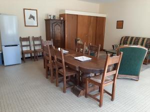 Un comedor con mesa y sillas de madera. en Gîte tout inclus avec parc, proche de Joinville, pour 10 personnes et activités variées - FR-1-611-102, en Bettaincourt-sur-Rognon