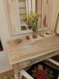 un tavolo in legno con specchio e fiori di CASA DI STELLA a Sabbio Chiese