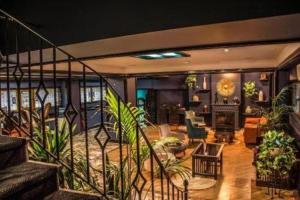 una sala de estar con plantas y una escalera en Hazz Hotel en Baku