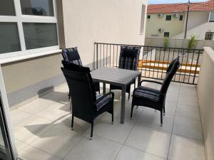 4 sillas y mesa en un balcón con mesa y sillas en 4 Sterne Studioapartment Blue, en Kaštela
