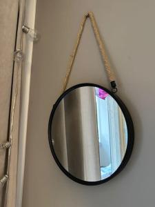 a mirror hanging on a wall with a chain at Stunning city center studio with balcony 37 m2 in Lappeenranta