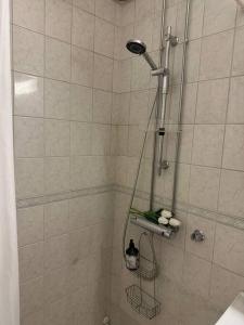 a shower with a shower head in a bathroom at Stunning city center studio with balcony 37 m2 in Lappeenranta