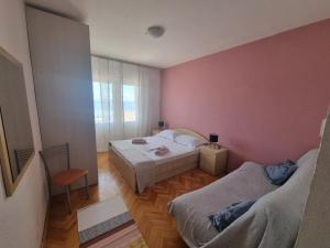 two beds in a room with pink walls at Podgora apartment no.5 in Podgora