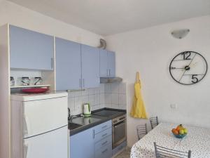 a kitchen with a table and a clock on the wall at Podgora apartment no.5 in Podgora