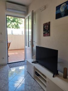 a living room with a flat screen tv on a wall at Podgora apartment no.5 in Podgora