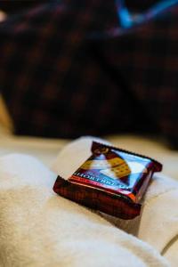 a bar of chocolate sitting on top of a bed at Caledonia Suite - Netflix Free Parking in Glasgow