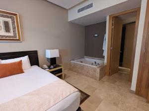 a hotel room with a bed and a bath tub at Vidanta Riviera Maya in Puerto Morelos