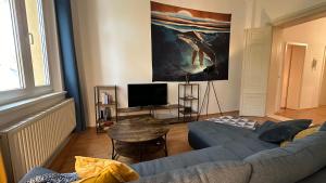 sala de estar con sofá y mesa en MiCasa TuCasa - Gemütliche und stilvolle 2-R Wohnung am Steintor, en Halle an der Saale